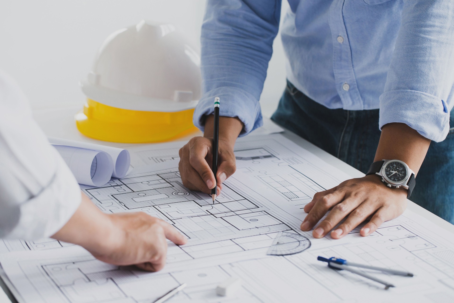 reunión de ingenieros para un proyecto arquitectónico. trabajar con el socio y las herramientas de ingeniería que trabajan en el proyecto arquitectónico del modelo en el sitio de construcción en el escritorio en la oficina.